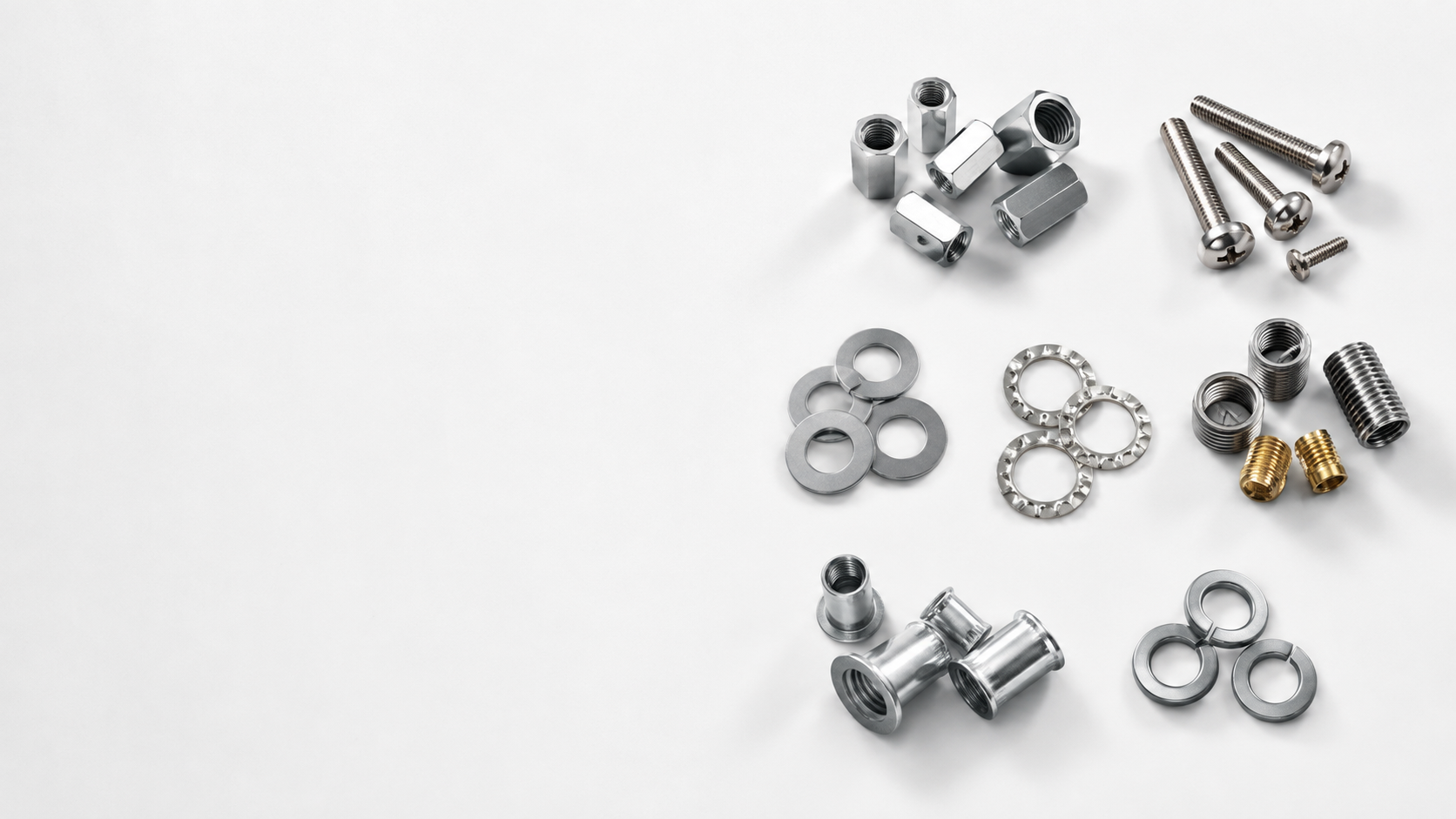 Stainless steel nuts, bolts, screws and washers arranged on a light surface
